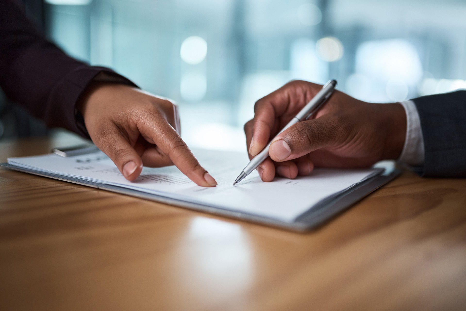 Cropped shot of two businesspeople filling in paperwork in an office